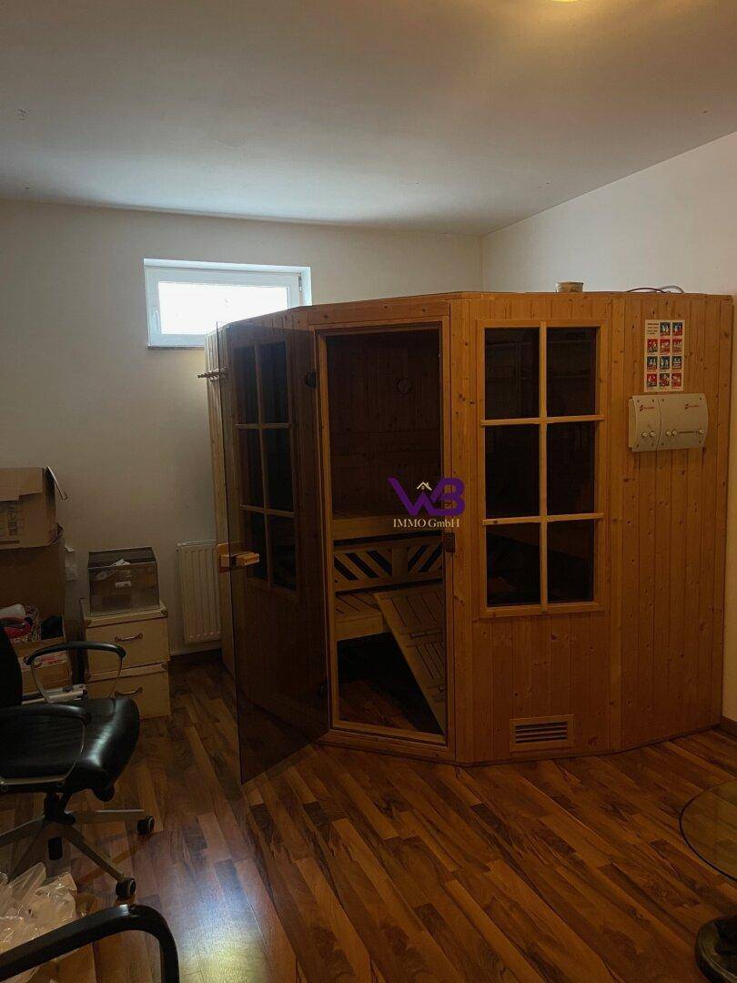 Wellnessbereich mit holzverkleideter Sauna und Fenster für natürliche Belichtung.
