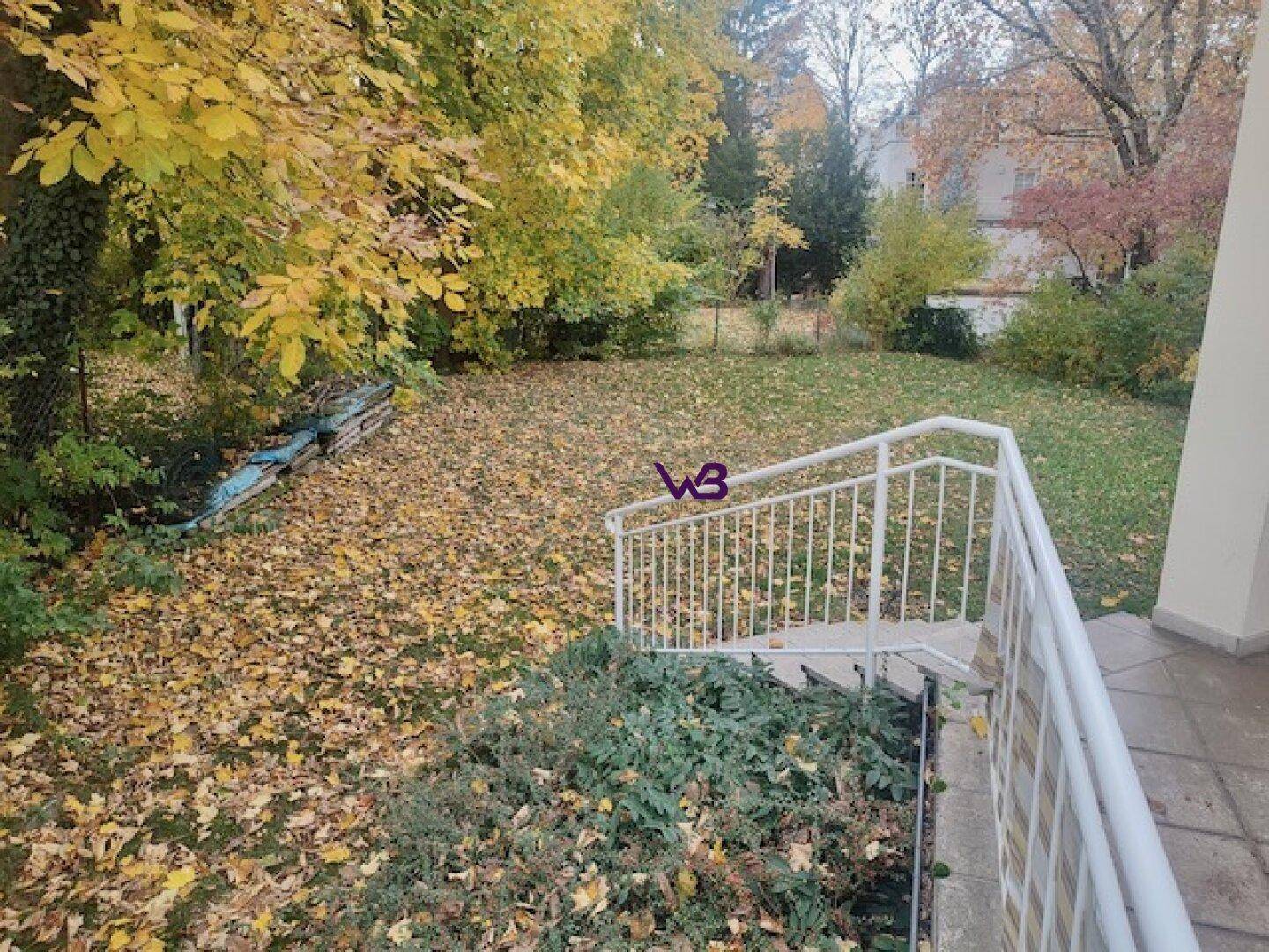 Großer Garten mit Rasenfläche, Bäumen und herbstlicher Färbung, ideal zum Entspannen.