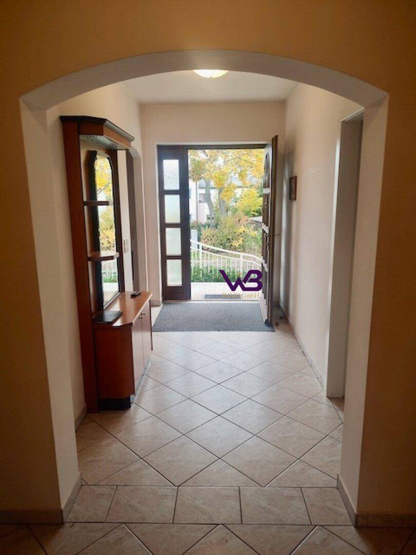 Eingangsbereich mit Fliesenboden, Garderobe und Blick zur Haustür.