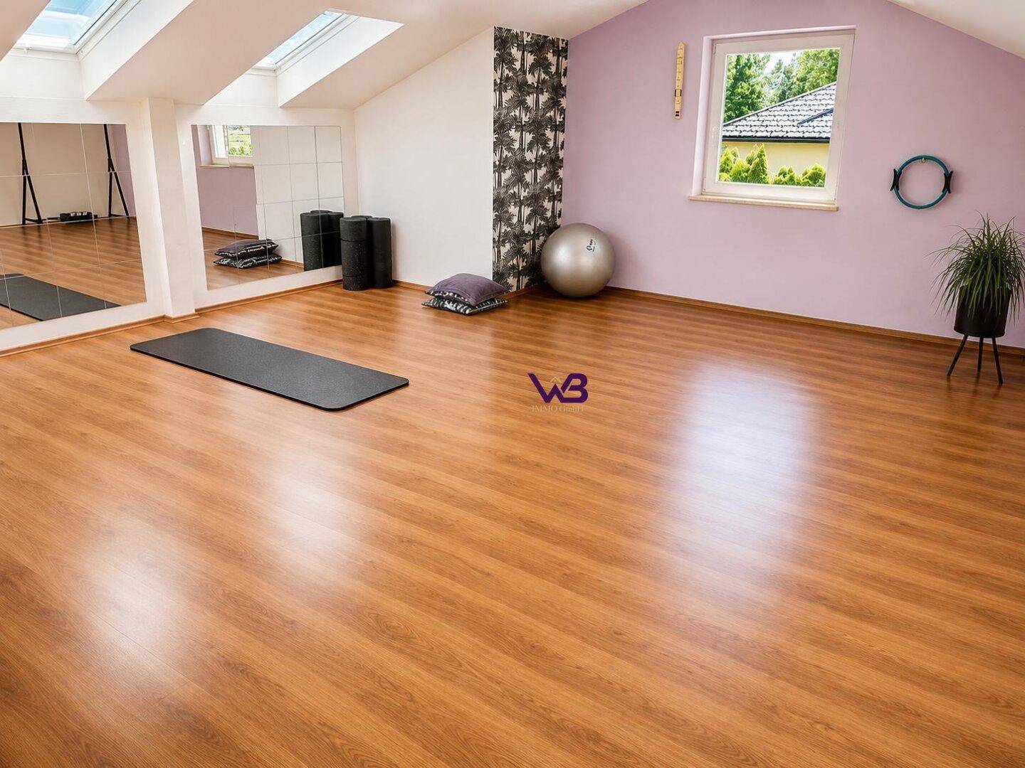 Geräumiger Fitnessraum im Dachgeschoss mit Holzboden, Spiegelwand und Oberlichtern für viel Licht.