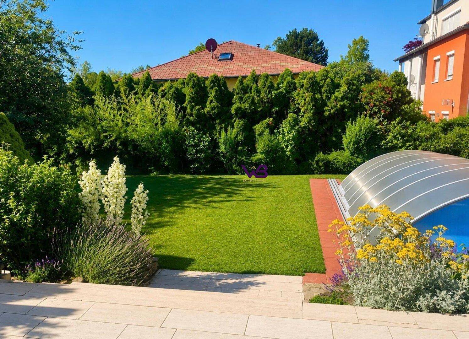 Weitläufiger Gartenbereich mit Rasen, Blumenbeeten und einem überdachten Pool, umgeben von hohen Hecken.