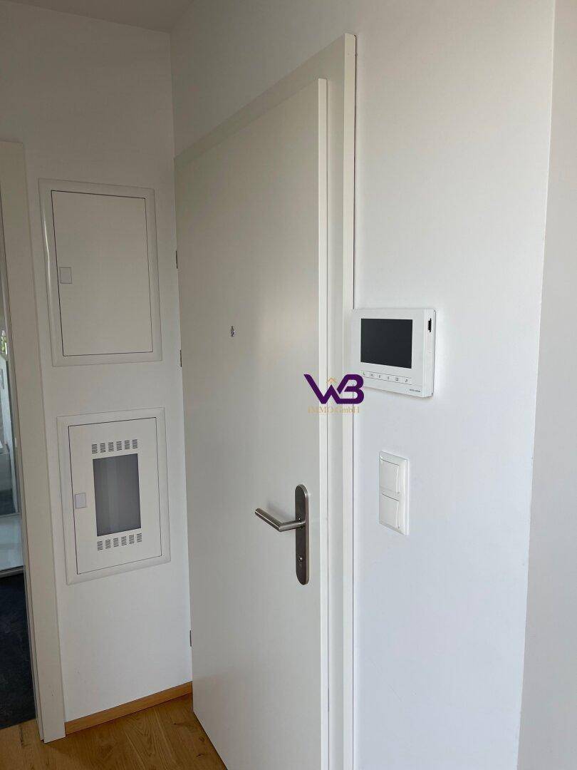 Eingangsbereich mit Gegensprechanlage und Sicherungskästen an der Wand.