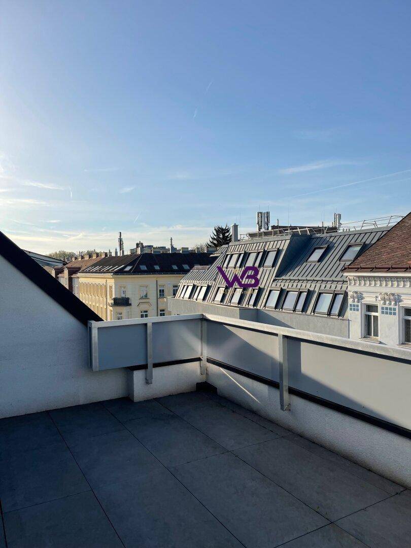 Geräumige Dachterrasse mit Blick über die Dächer der Stadt und weitem Horizont.