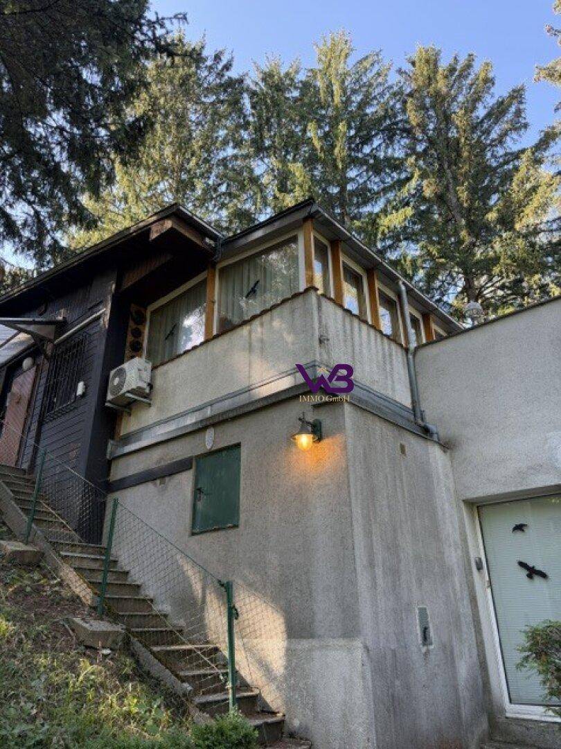 Außenansicht des Hauses mit Treppe, Betonfassade und Klimaanlage.