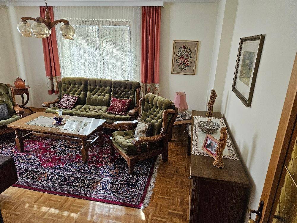 Wohnzimmer mit bequemen Sofas, Parkettboden und traditioneller Einrichtung.