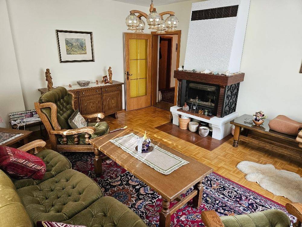 Gemütliches Wohnzimmer mit Kamin, Parkettboden und traditionellen Möbeln.