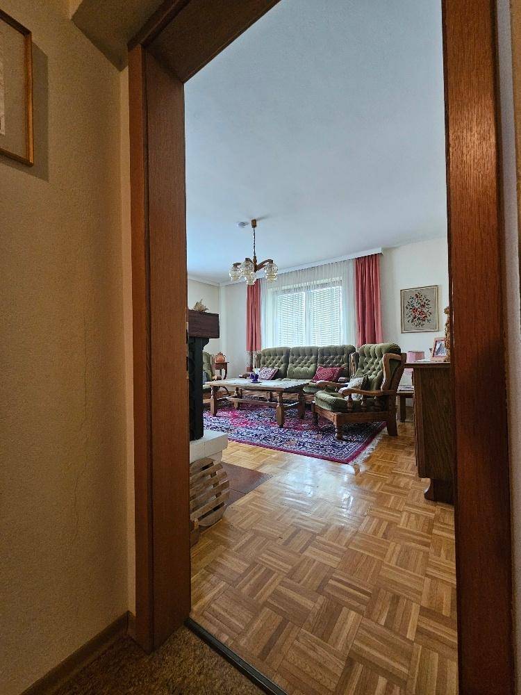 Eingangsbereich zum Wohnzimmer mit Parkettboden und traditioneller Einrichtung.