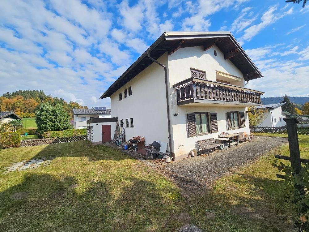 Seitenansicht des Hauses mit Gartenbereich, Nebengebäude und Blick auf die umliegende Landschaft.