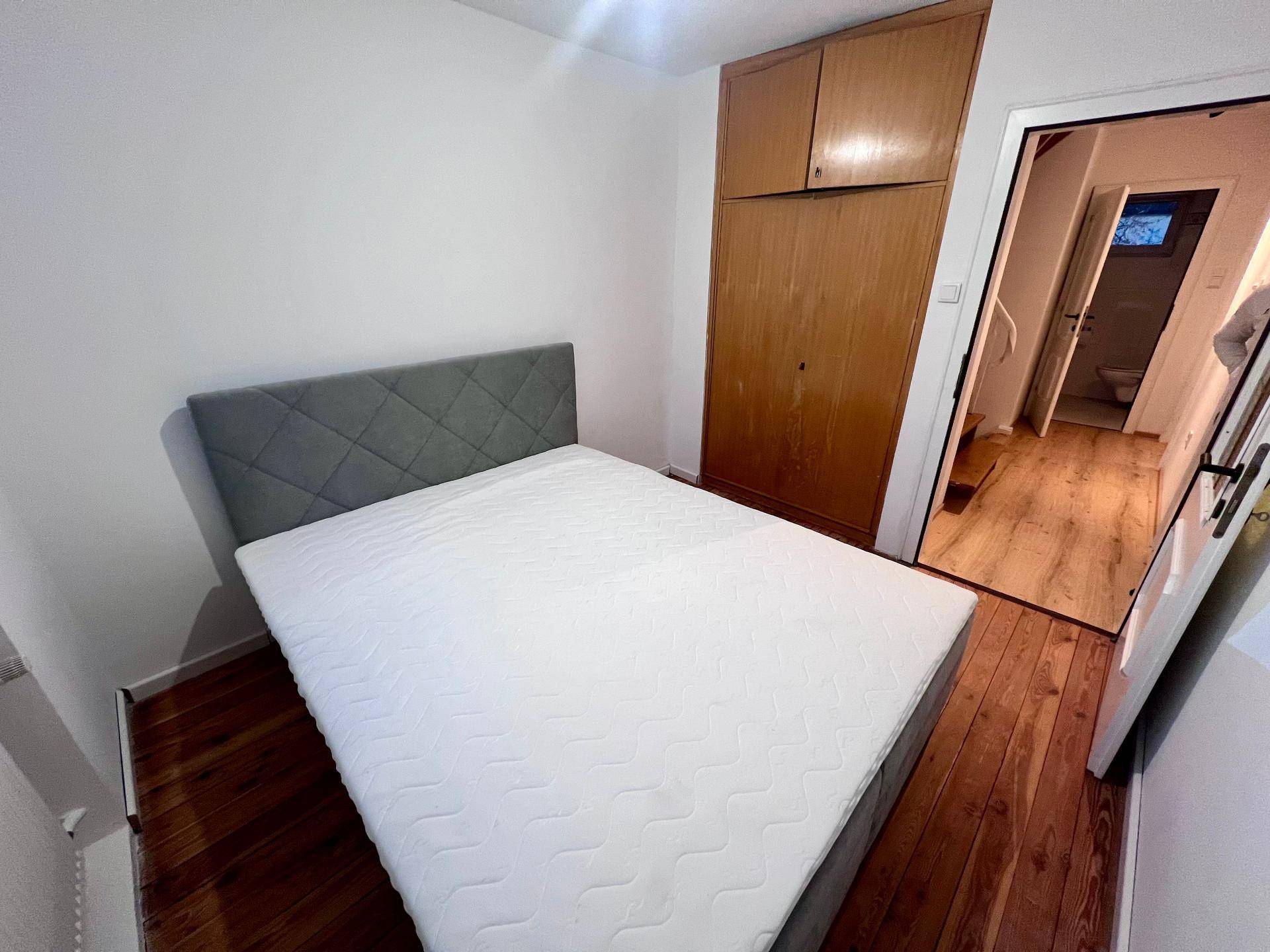 Schlafzimmer mit Doppelbett, Holzboden und praktischem Einbauschrank.