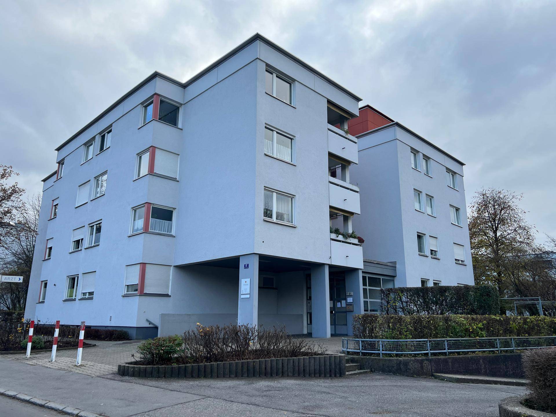 Mehrstöckiges Wohngebäude mit hellblauer Fassade und mehreren Fenstern.