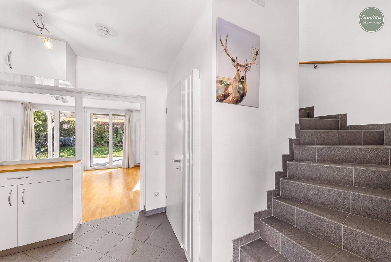 Eingangsbereich mit Fliesenboden, Treppe und Zugang zum Wohnbereich.