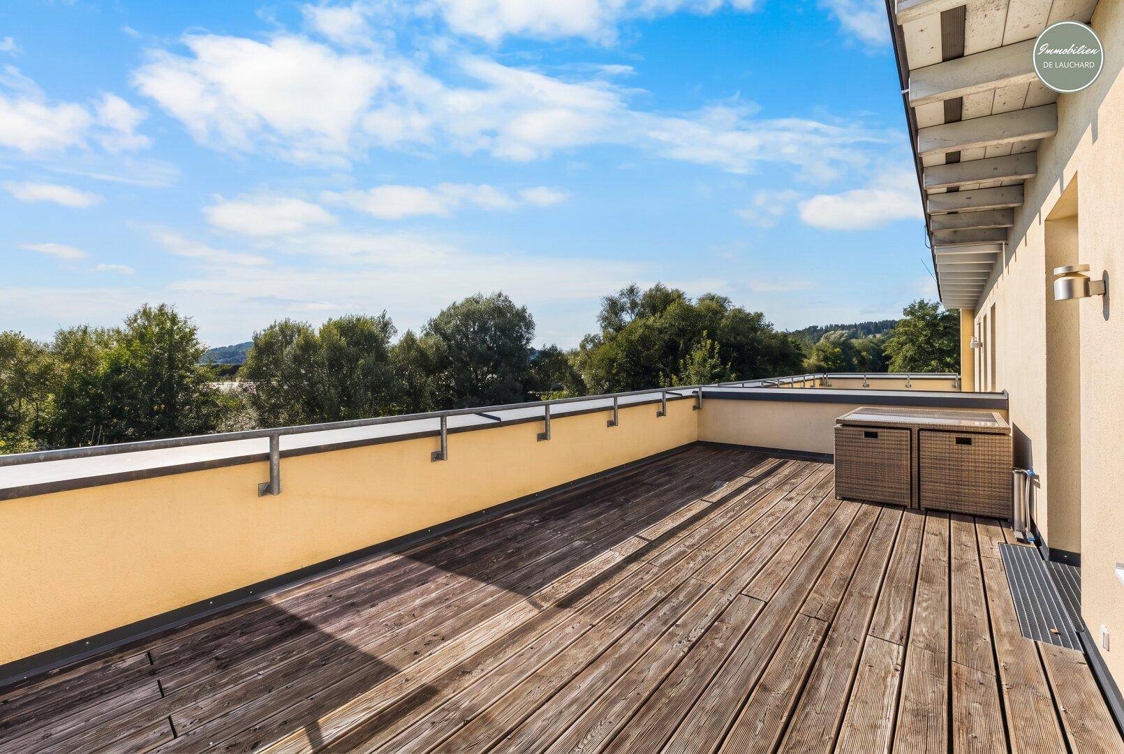 Große Holzterrasse mit weitem Blick ins Grüne und viel Platz zum Entspannen im Freien.