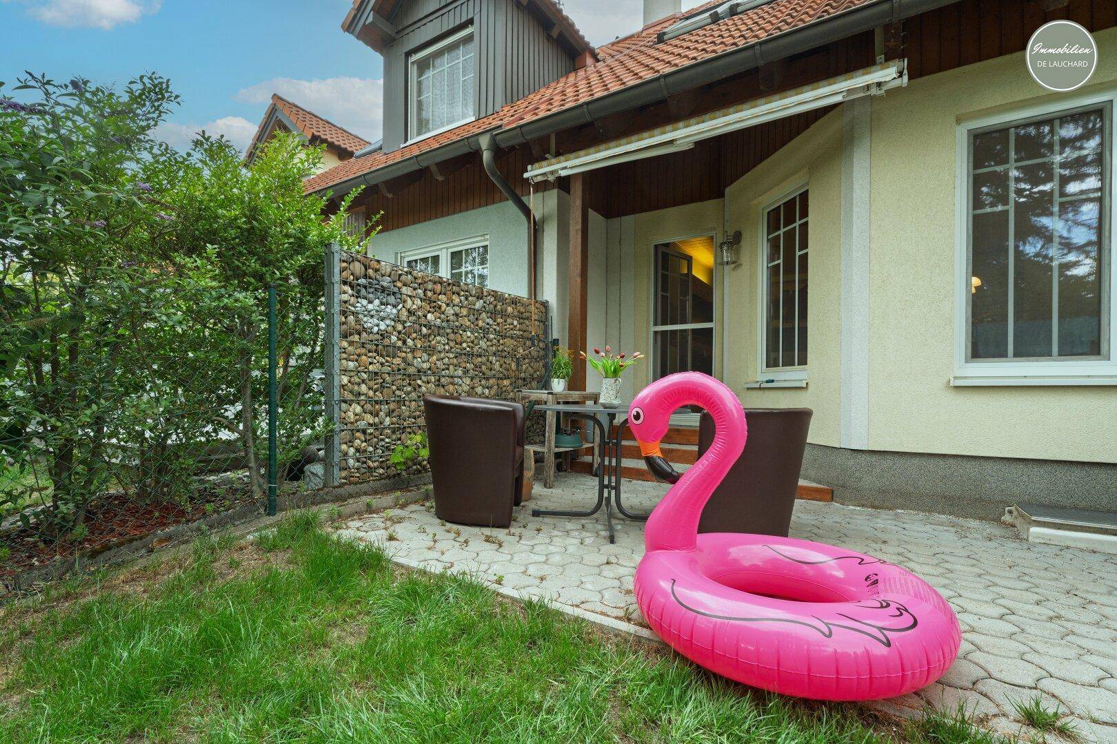 Ruhige Terrasse am Haus mit Gartenblick und Sitzgelegenheiten im Freien.