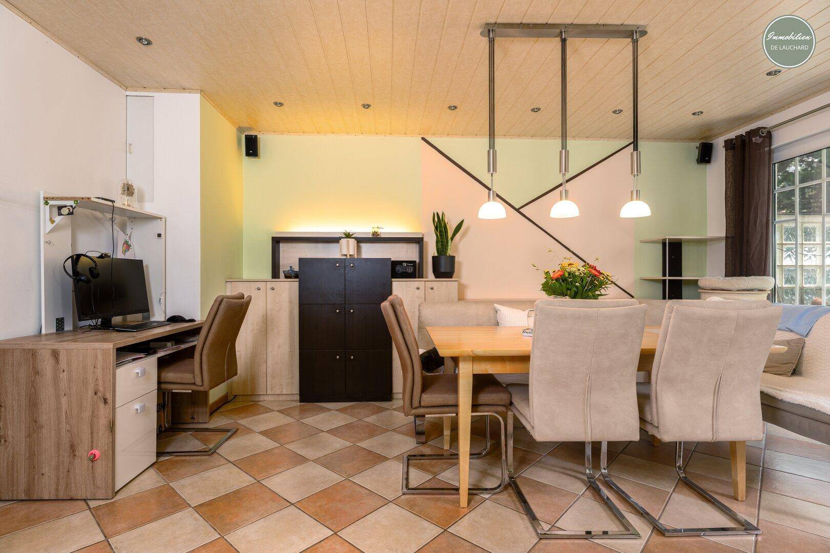 Essbereich mit großem Tisch und integriertem Arbeitsplatz, ideal für Home-Office.