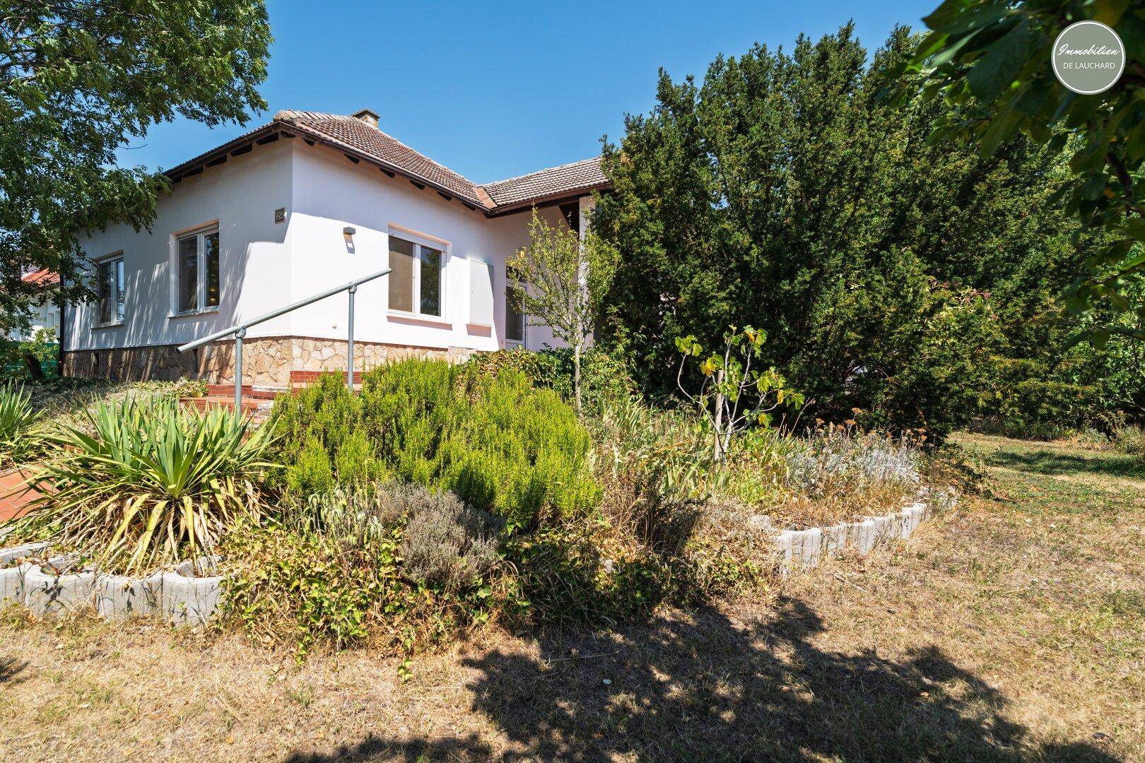 Vorderseite des Hauses mit gepflegtem Vorgarten und Treppe zum Eingangsbereich.