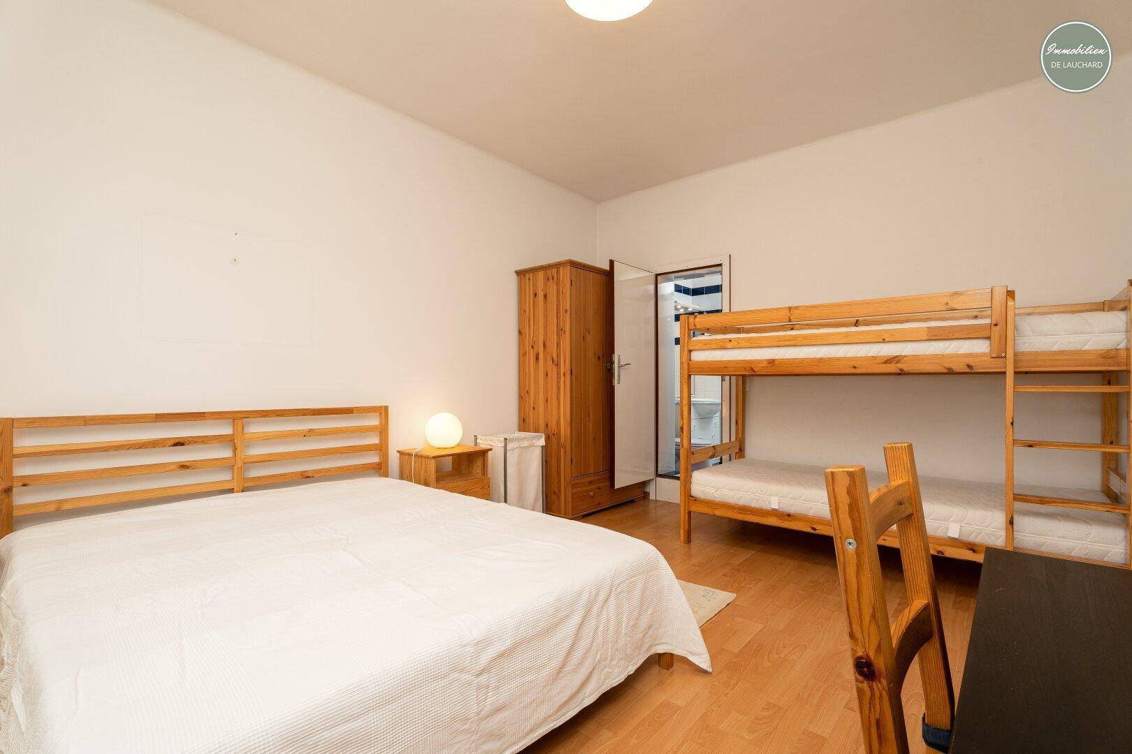Geräumiges Schlafzimmer mit Doppelbett und Etagenbett, ideal für Familien oder Gäste.