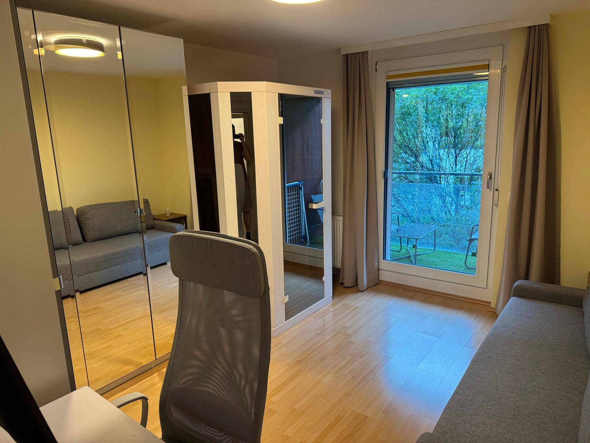 Arbeitszimmer mit Schlafsofa, Spiegelschrank und einer integrierten Sauna.