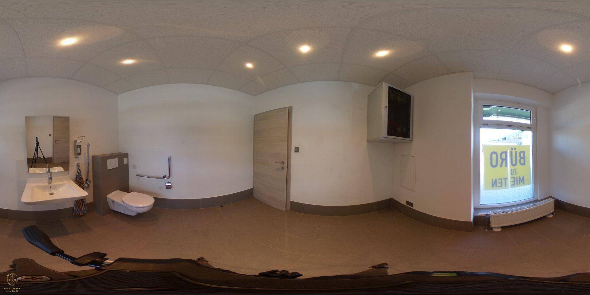 Panoramaaufnahme eines Badezimmers mit Waschbecken, WC und Fenster, das viel Licht hereinlässt.