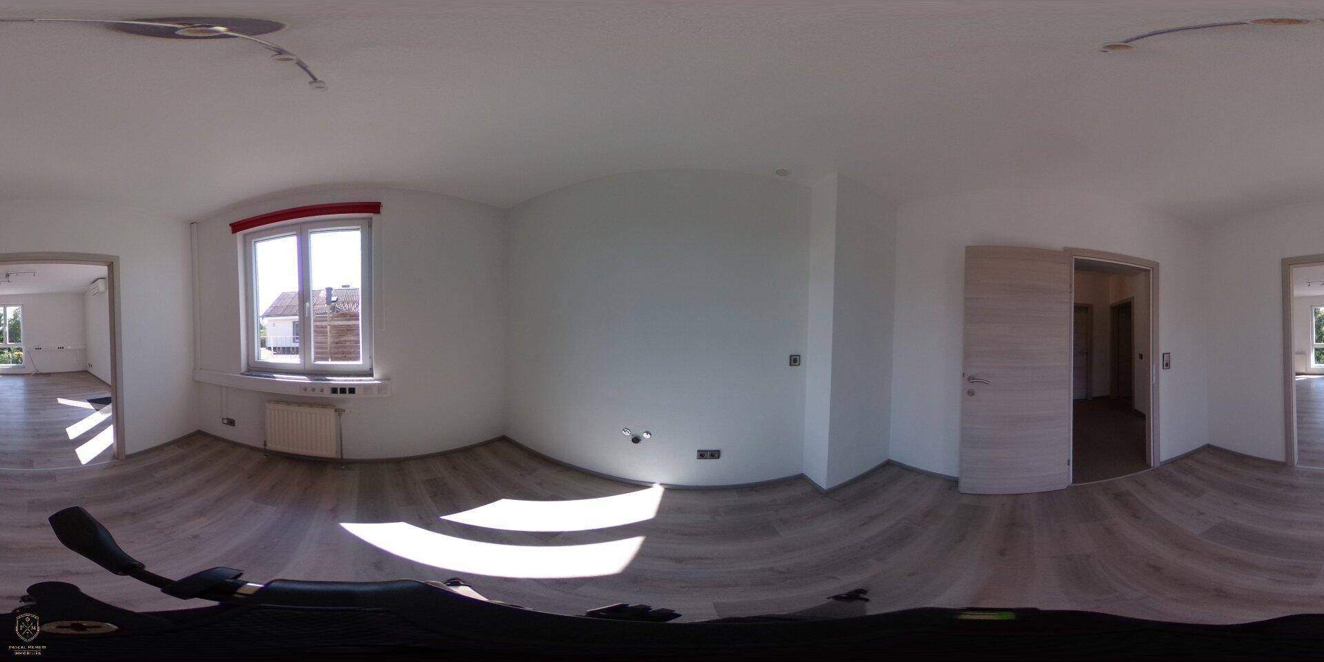 Panoramaaufnahme eines leeren Wohnzimmers mit Laminatboden und großem Fenster.