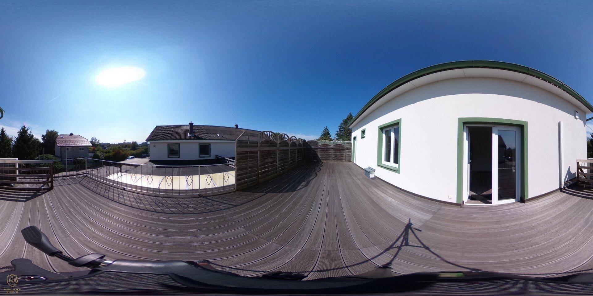 Panoramaaufnahme einer großen Holzterrasse auf dem Dach mit Blick auf die Umgebung.