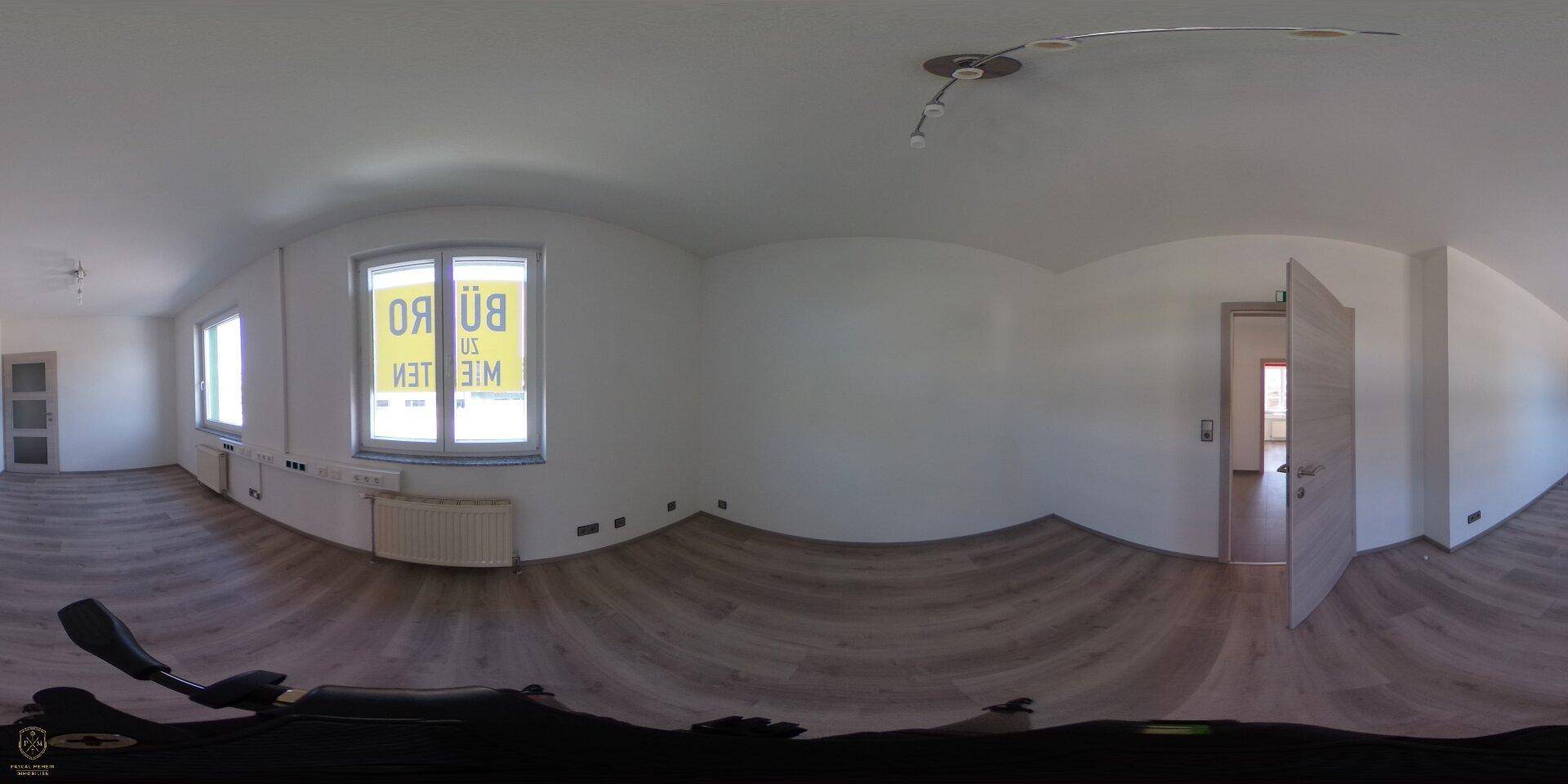 Panoramaaufnahme eines leeren Büroraums mit Laminatboden und großem Fenster.