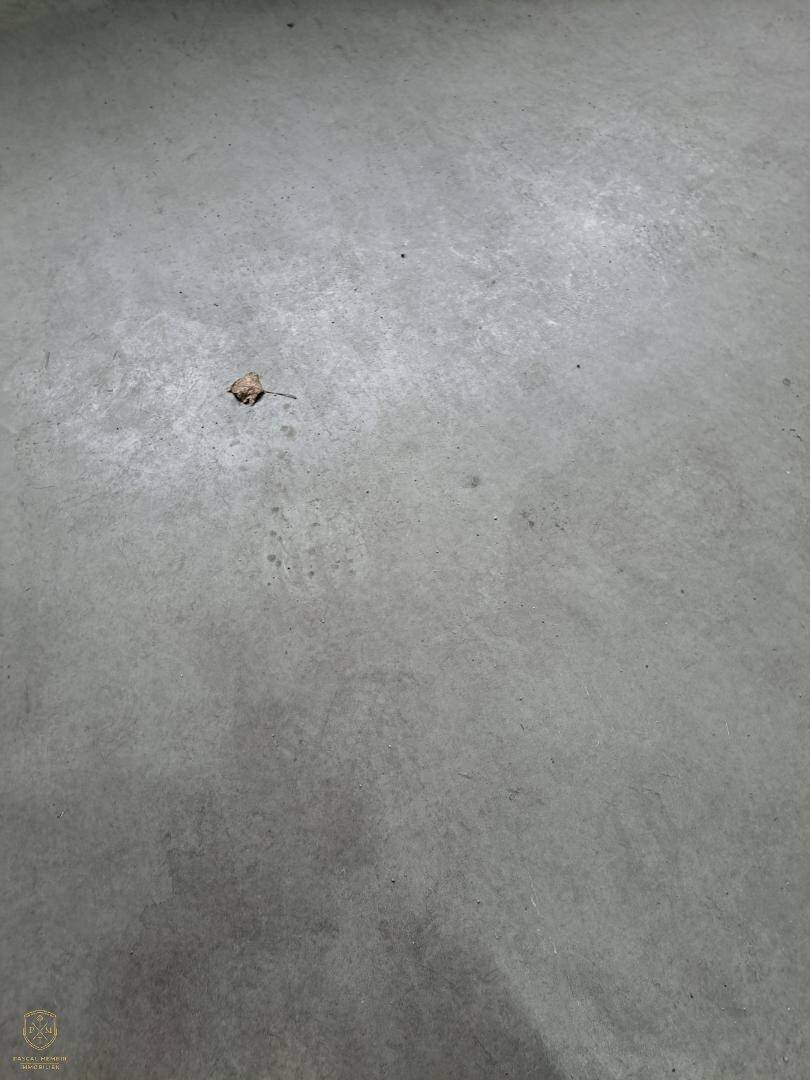 Nahaufnahme eines grauen Betonbodens mit einer kleinen Verunreinigung.