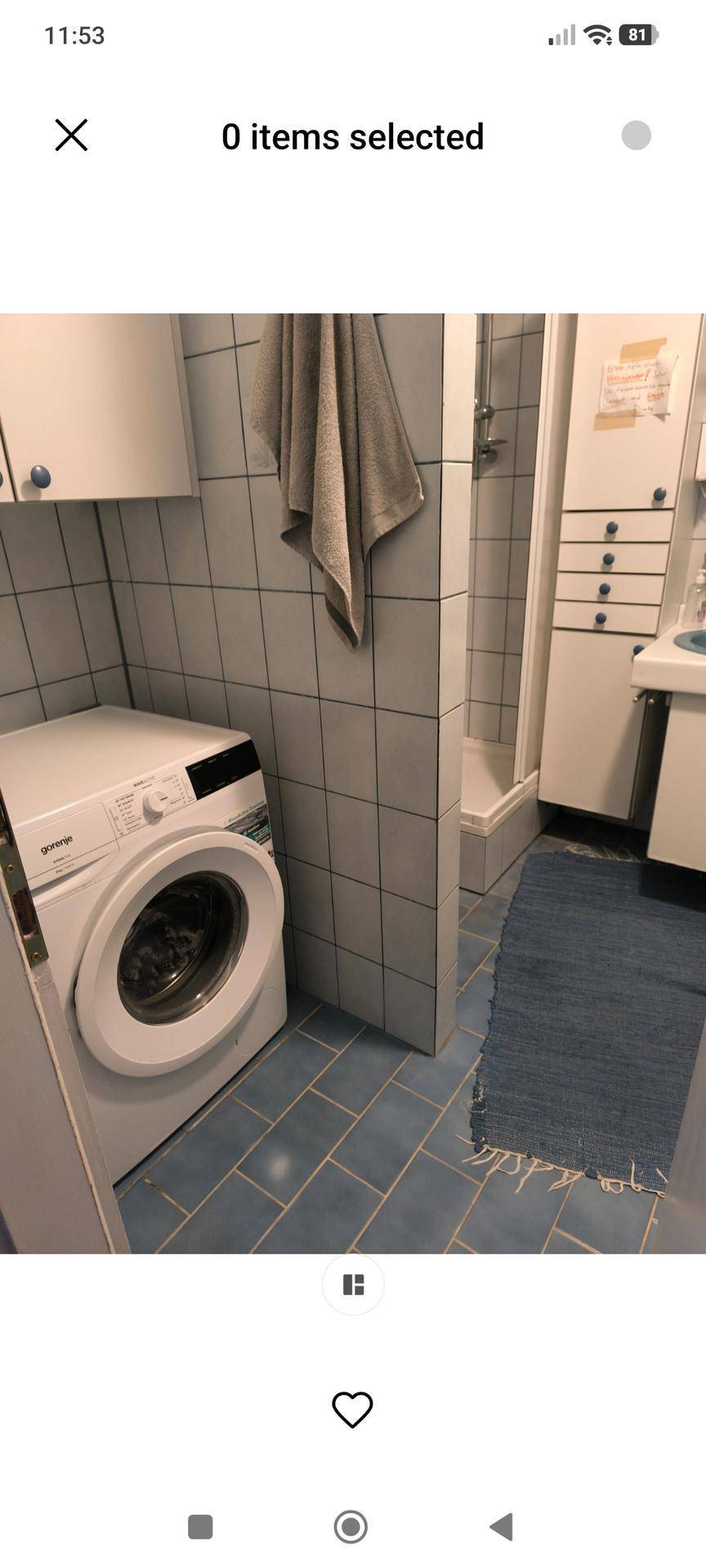 Praktischer Waschraum mit Waschmaschine und Duschkabine, ausgestattet mit hellblauen Bodenfliesen.