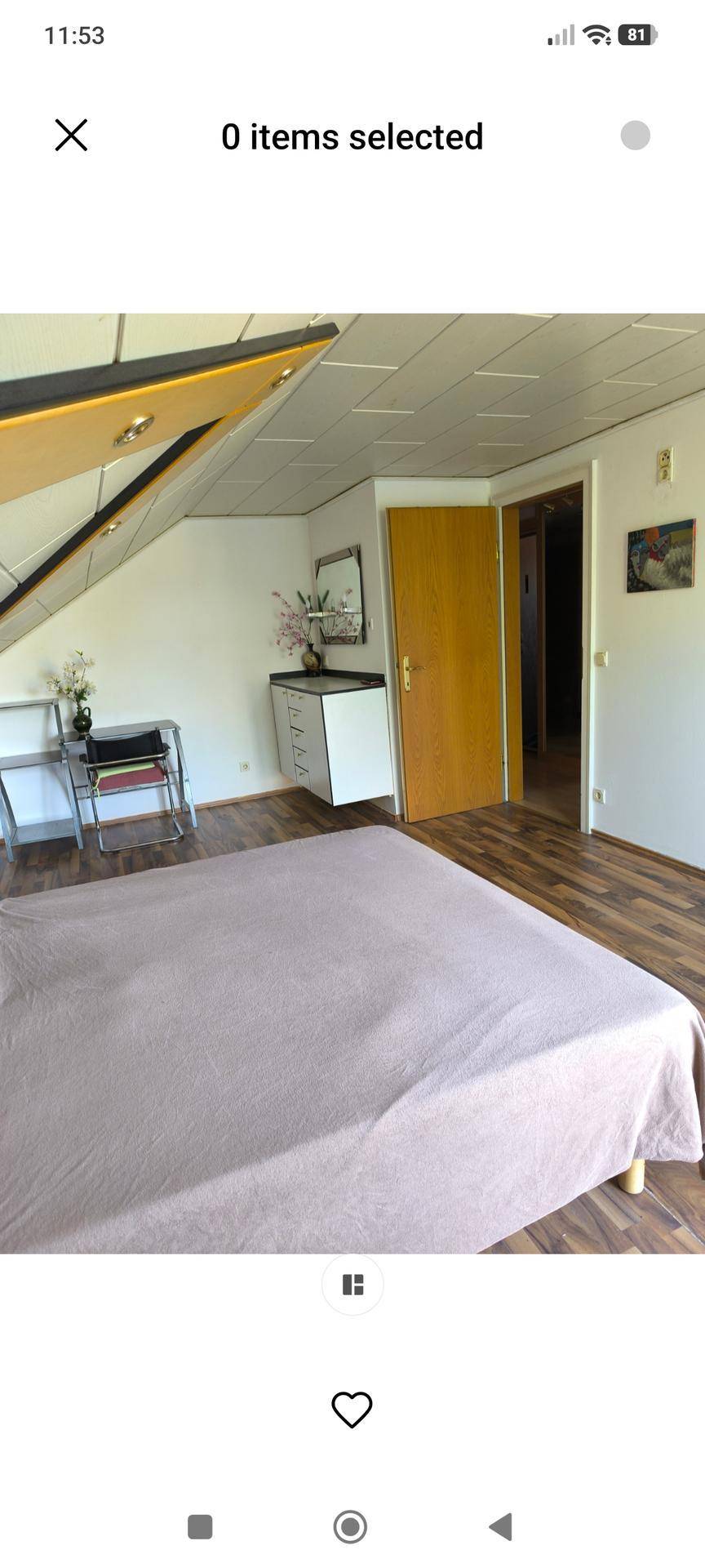 Helles Schlafzimmer im Dachgeschoss mit Holzboden, einem kleinen Schreibtisch und Zugang zu weiteren Räumen.