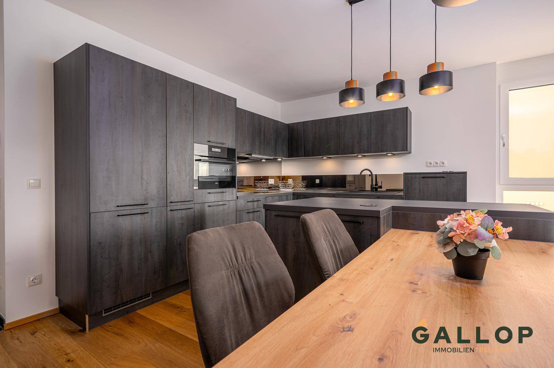 Moderne Einbauküche in dunklem Holzdekor mit integrierten Geräten und viel Stauraum.