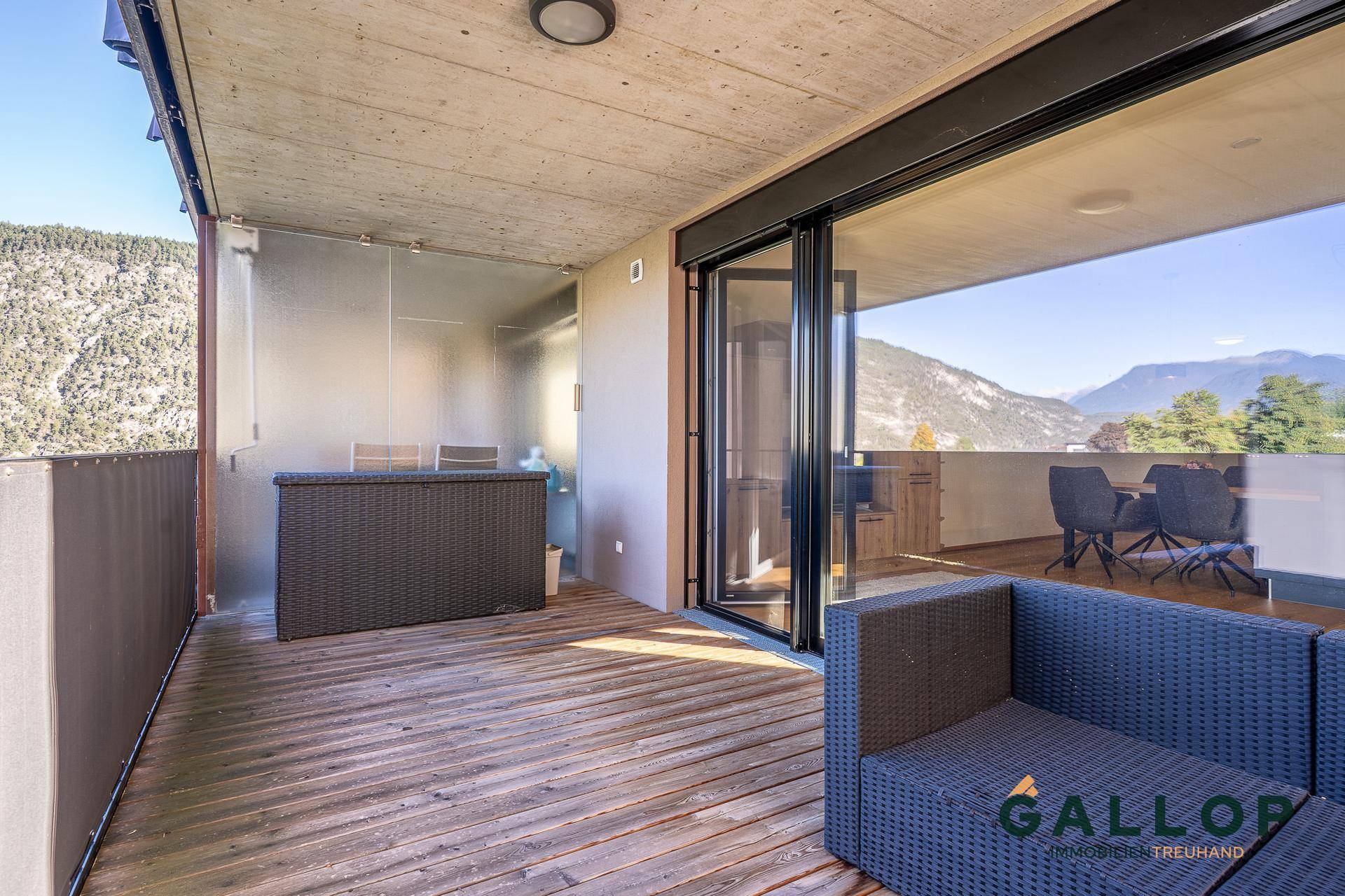 Großer Balkon mit Holzboden und Sitzgelegenheiten, ideal zum Entspannen mit Bergblick.