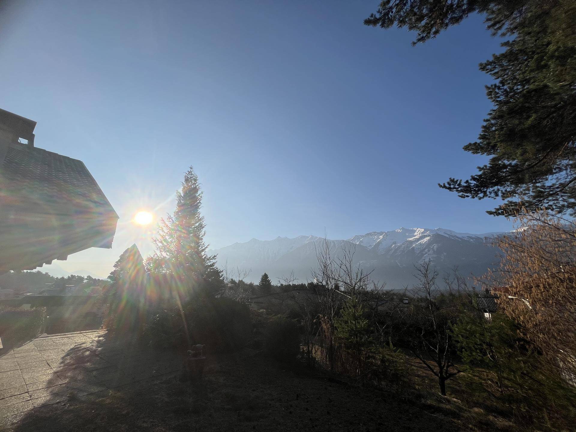 Panoramablick auf die schneebedeckten Berge und die umliegende Landschaft, eingefangen bei strahlendem Sonnenschein.