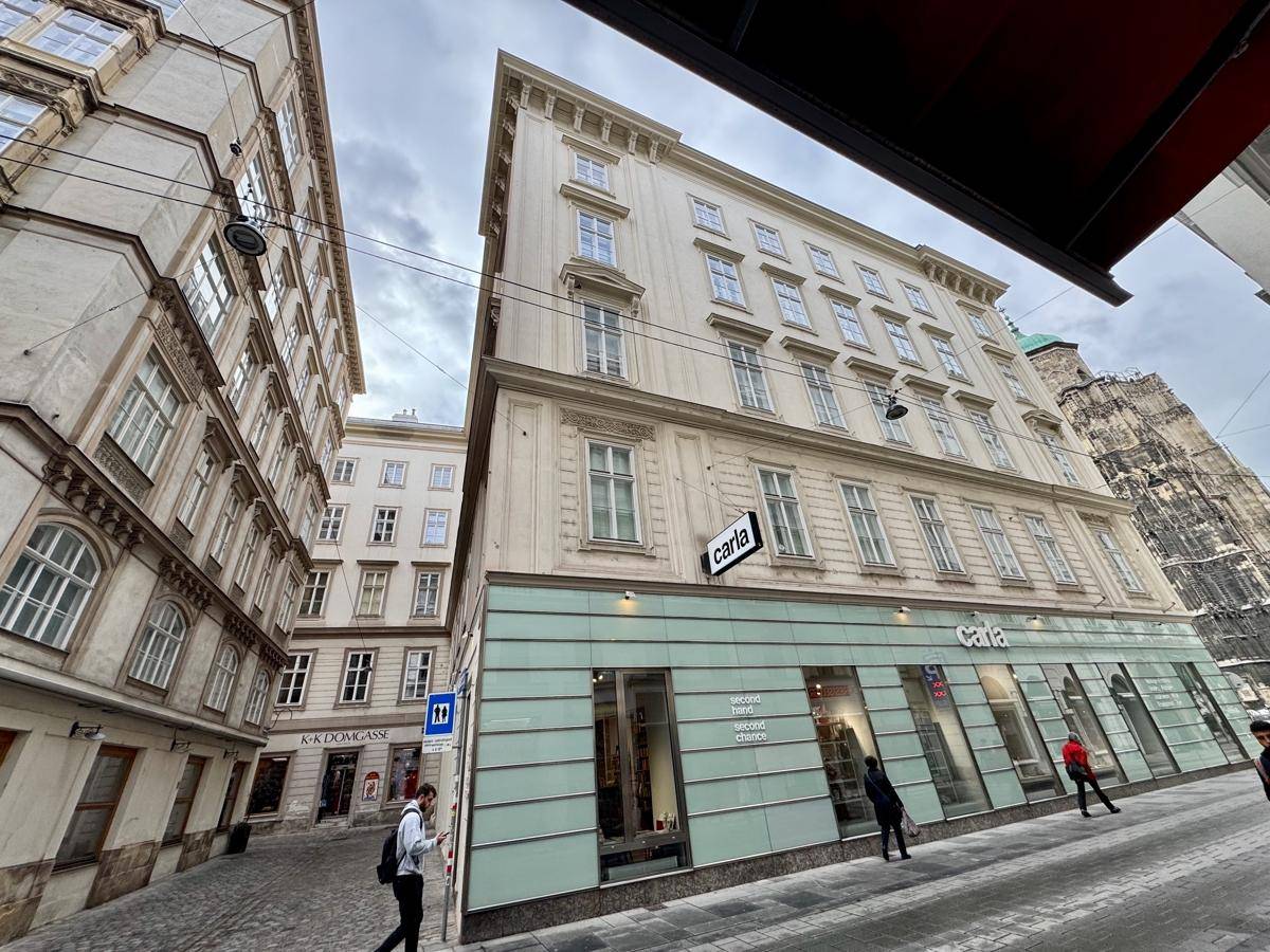 Historisches Gebäude mit modernisierter Ladenfront im Erdgeschoss und Blick auf die Straße.