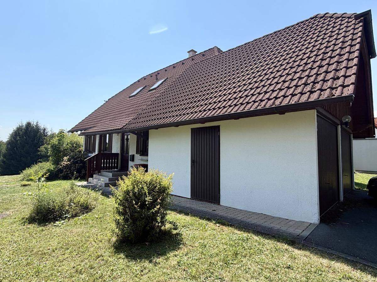 Seitenansicht des Hauses mit Garage und Zugang zum Gartenbereich.