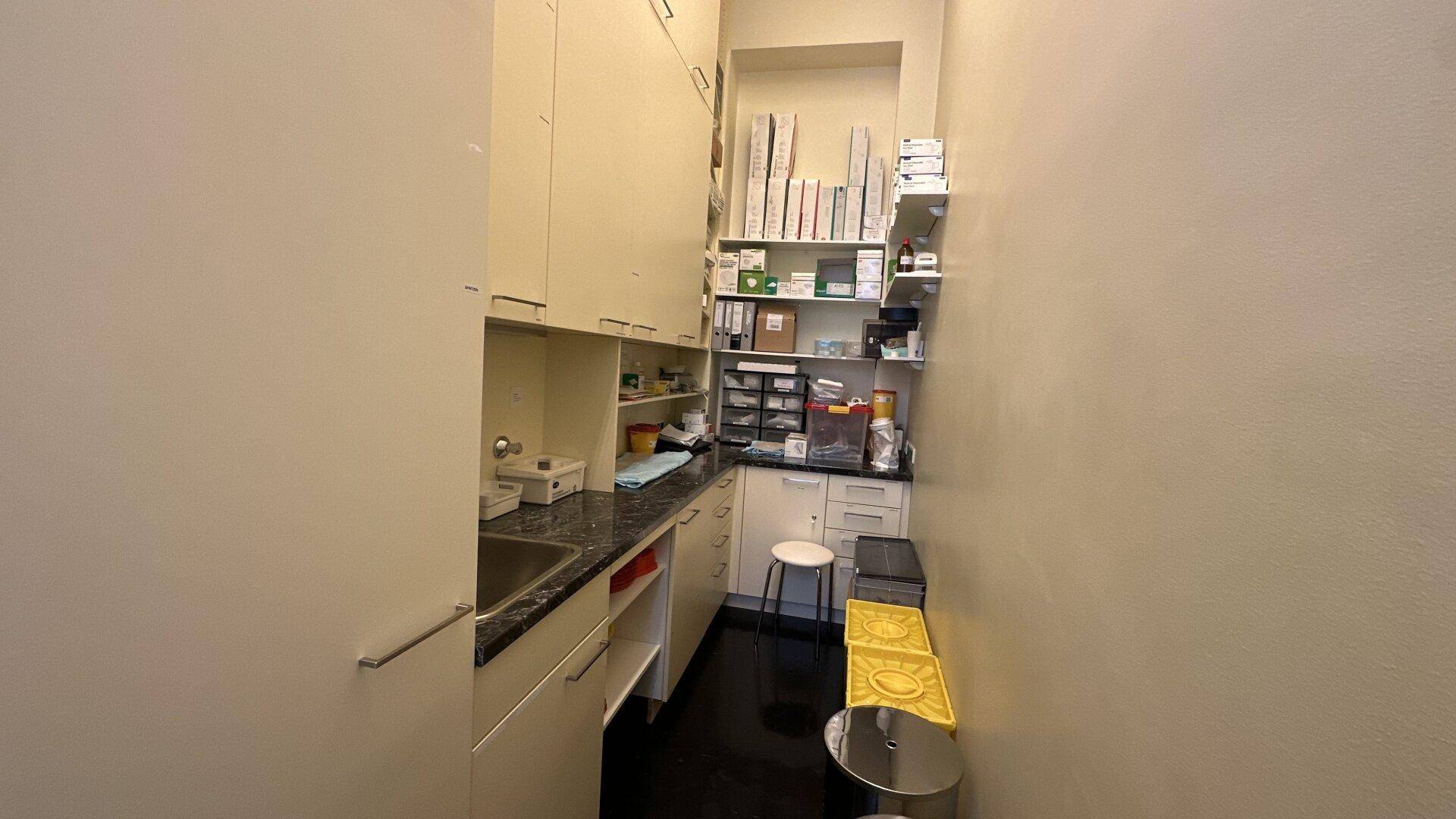 Schmaler Wirtschaftsraum mit umfangreichen Regalen, Arbeitsfläche und Spülbecken, ideal für Lagerung und Vorbereitung.