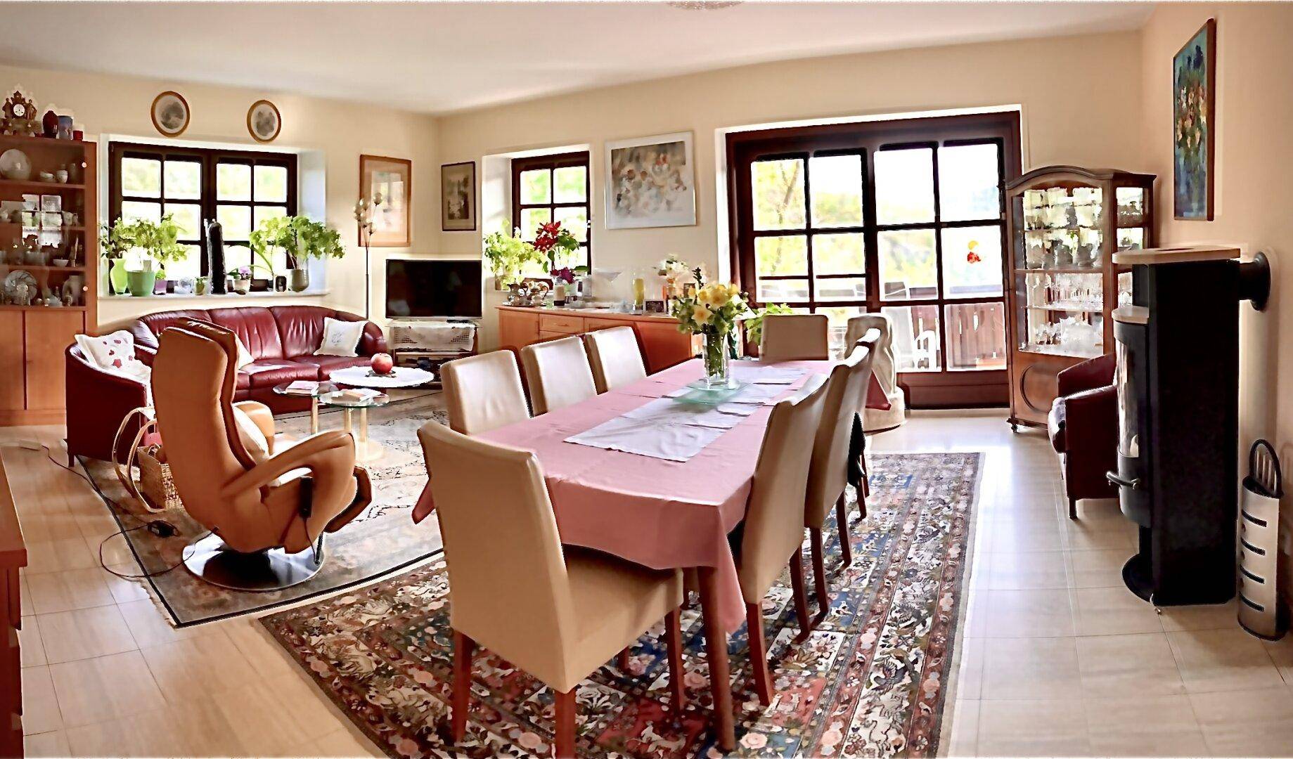Geräumiger Wohn- und Essbereich mit Parkettboden, großen Fenstern und Zugang zur Terrasse.