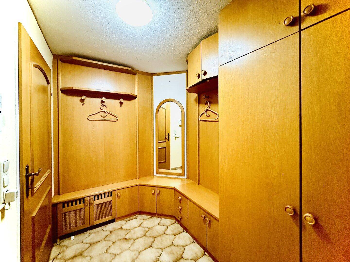 Eingangsbereich mit integrierten Holzschränken und Garderobe, praktisch gestaltet.