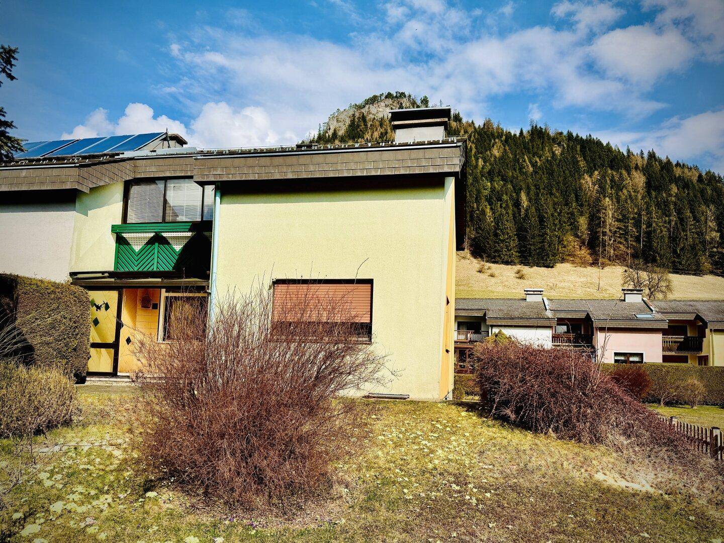 Weitläufige Ansicht des Hauses mit grüner Umgebung und Bergkulisse.