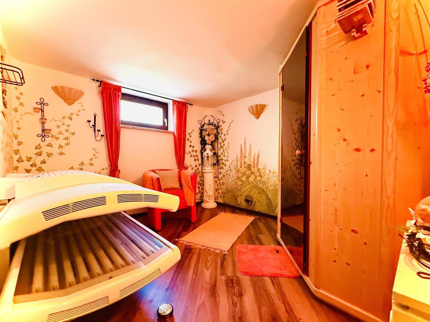 Wellnessbereich mit Solarium und dekorativen Wandmalereien für Entspannung.