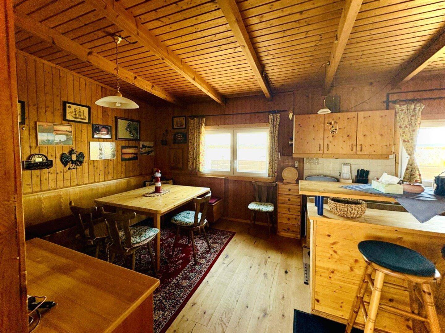 Heller Essbereich mit Holztisch, Stühlen und Blick auf die angrenzende Küche.