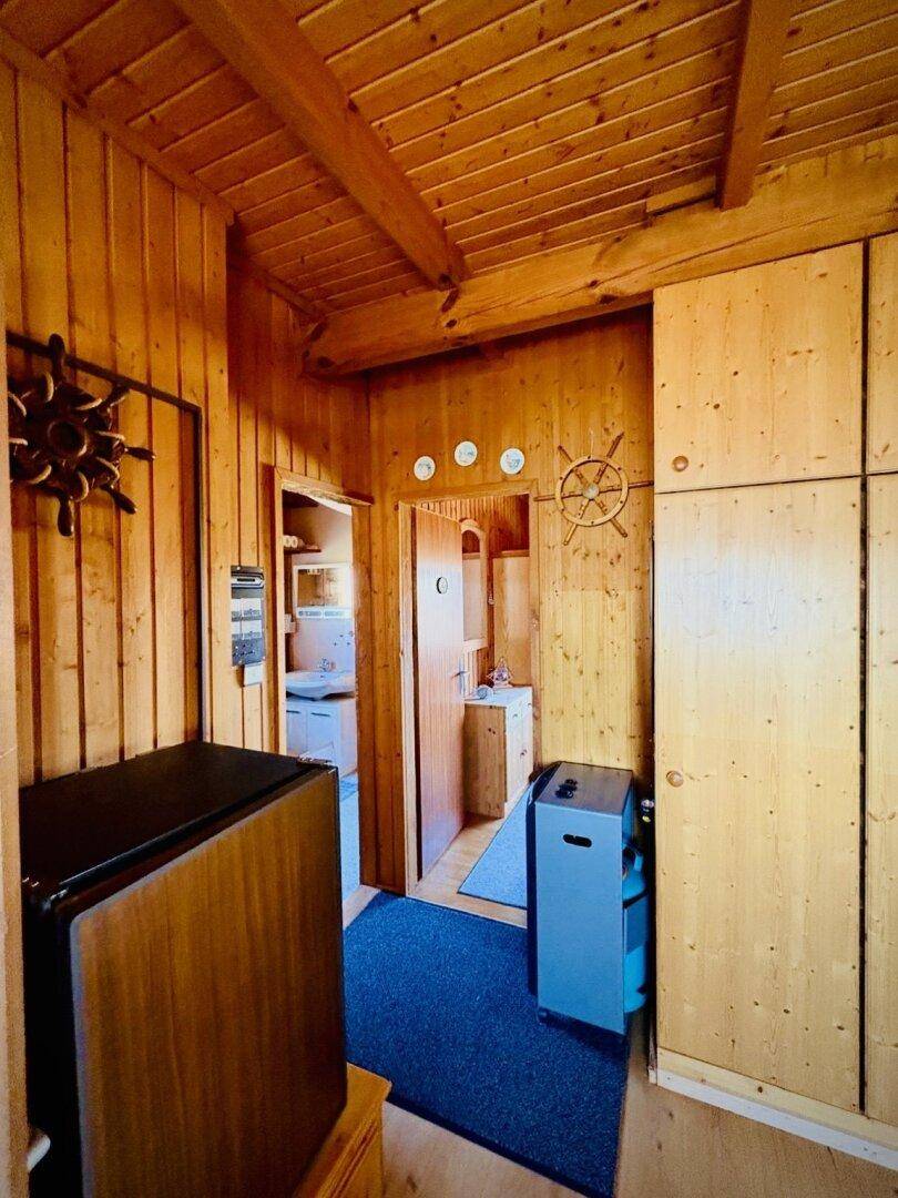 Schmaler Flur mit Holzverkleidung und Türen, die zu weiteren Räumen führen.