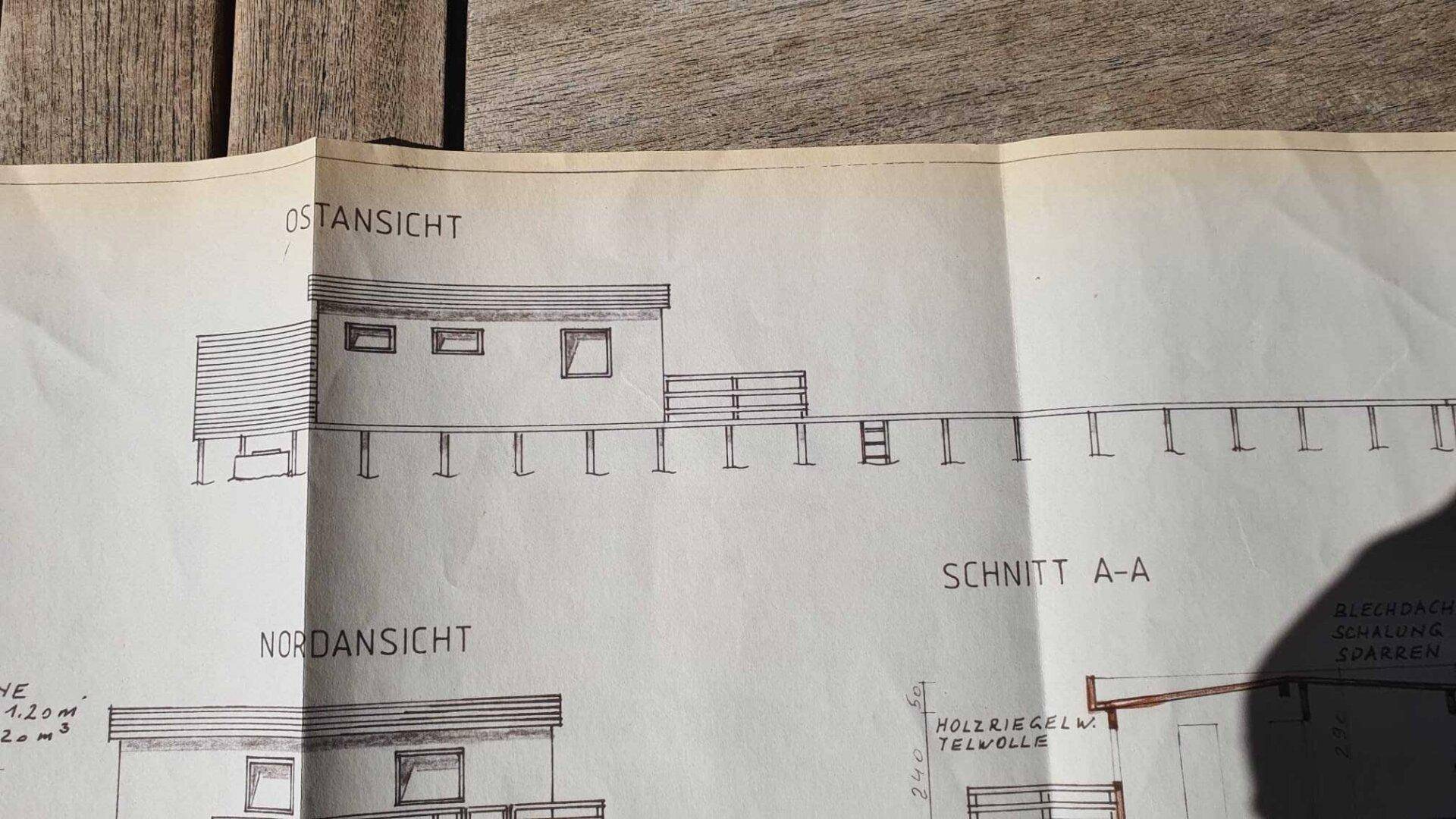 Ost- und Nordansicht des Gebäudes mit detailliertem Schnitt A-A und Holzriegelwand.
