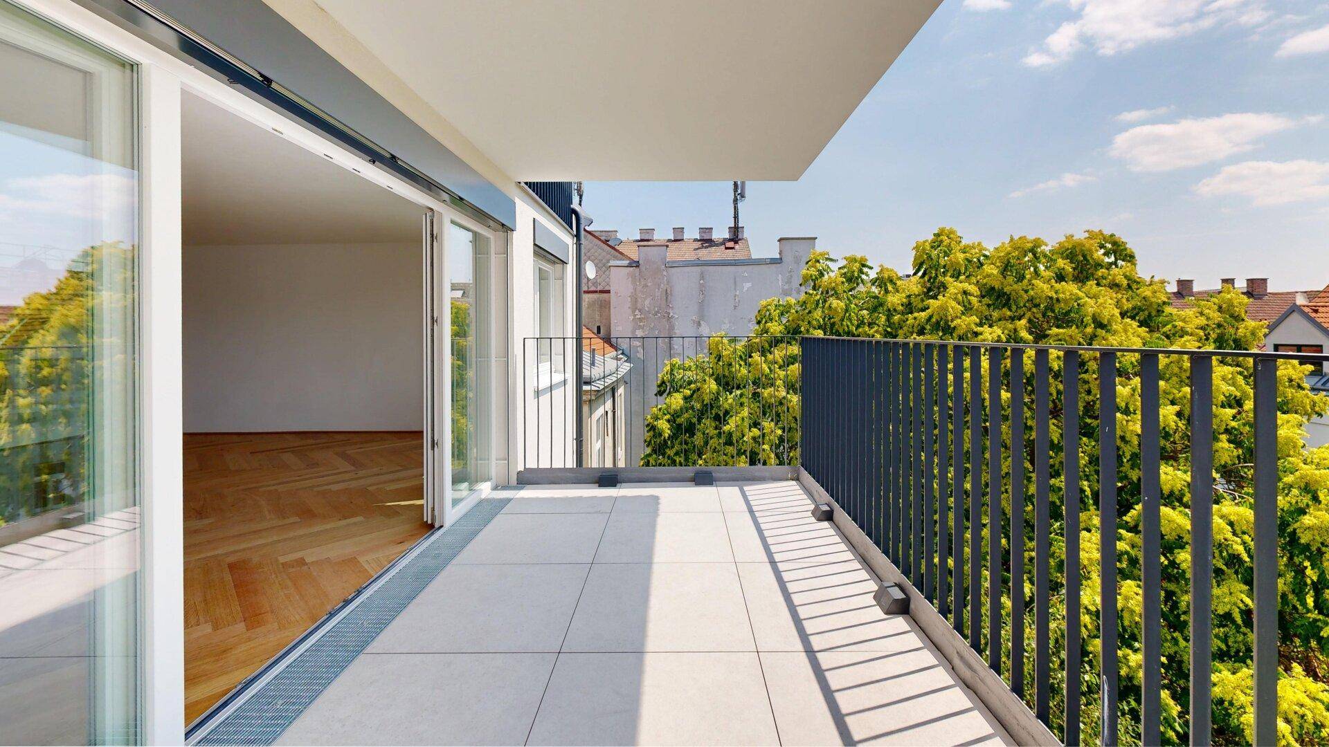 Heller Balkon mit moderner Brüstung und grüner Aussicht, ideal für entspannte Stunden im Freien.