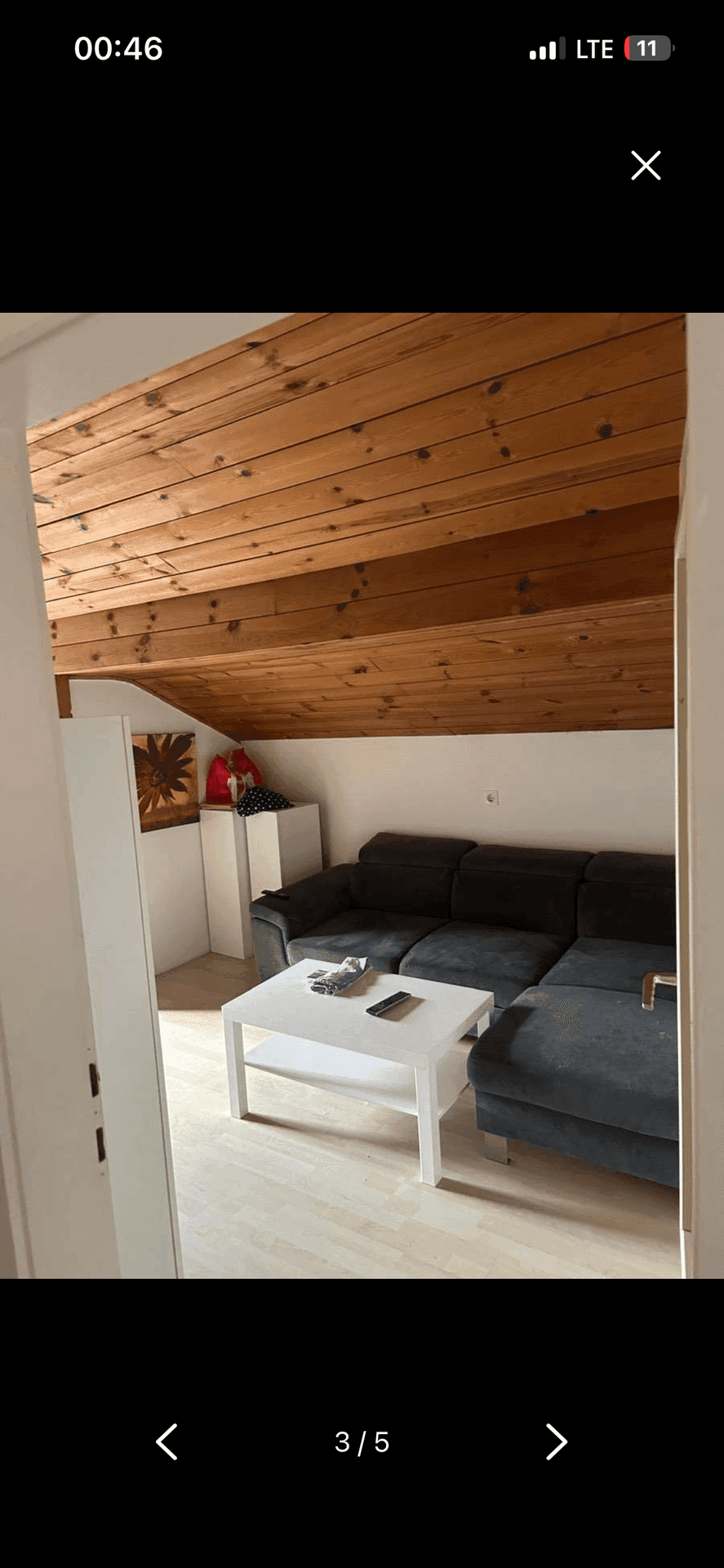 Helles Wohnzimmer im Dachgeschoss mit Holzbalkendecke, Dachschräge und moderner Einrichtung.