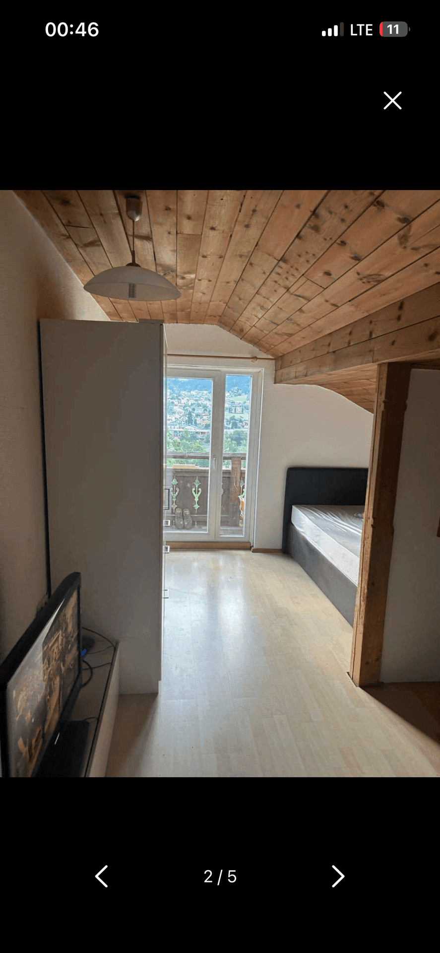 Schlafzimmer im Dachgeschoss mit Holzbalkendecke, Dachschräge und beeindruckendem Bergblick.