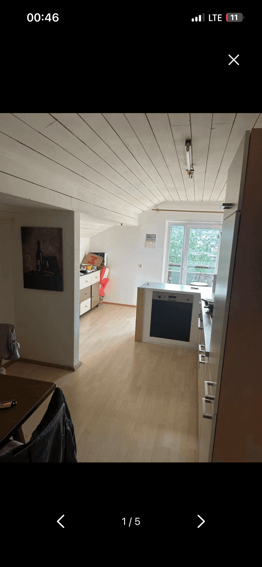 Funktionale Küche mit Holzbalkendecke, Dachschräge und Fenster mit Blick ins Grüne.