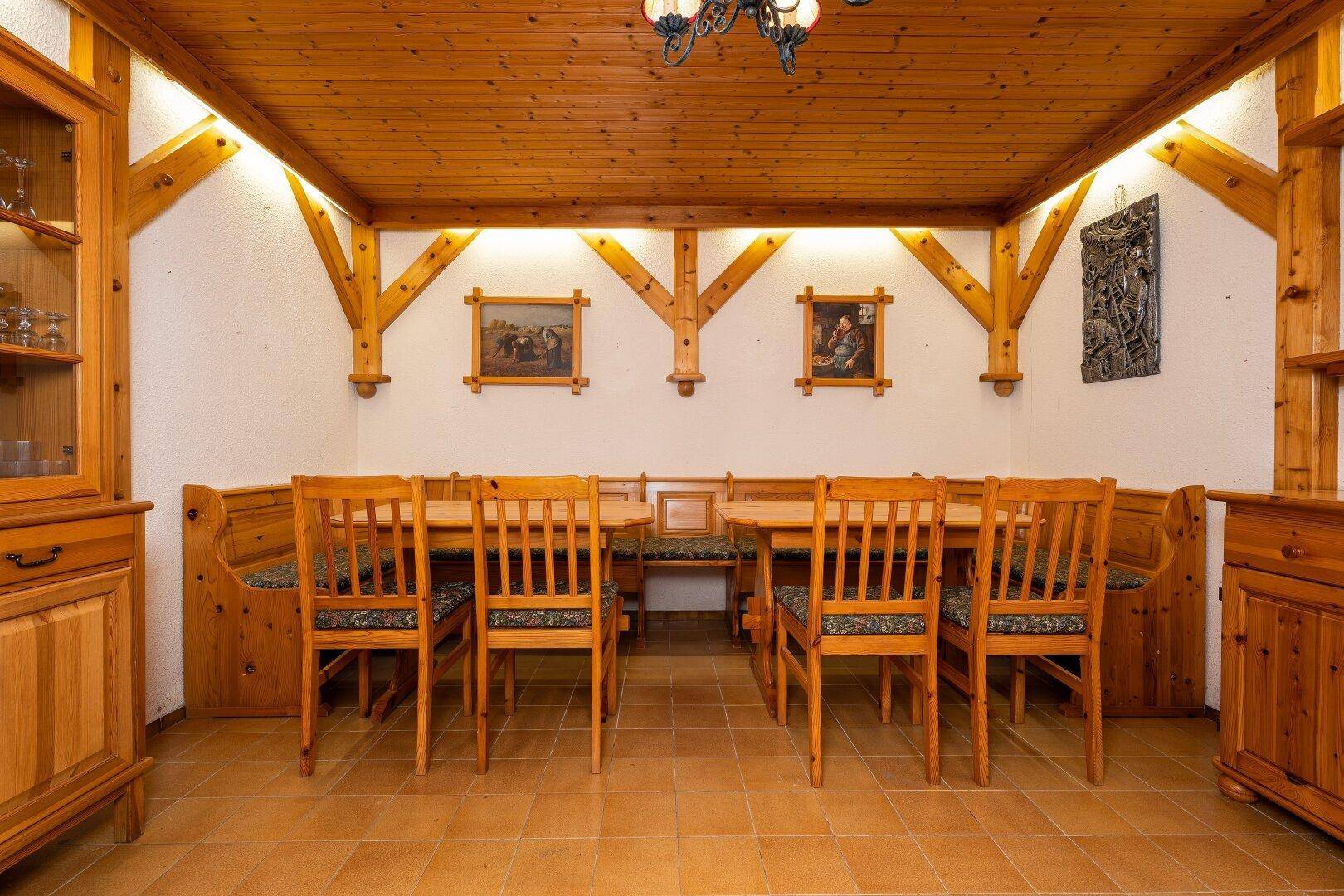 Traditioneller Essbereich mit Holzbalken, Holztisch und Bänken, ideal für gesellige Runden.