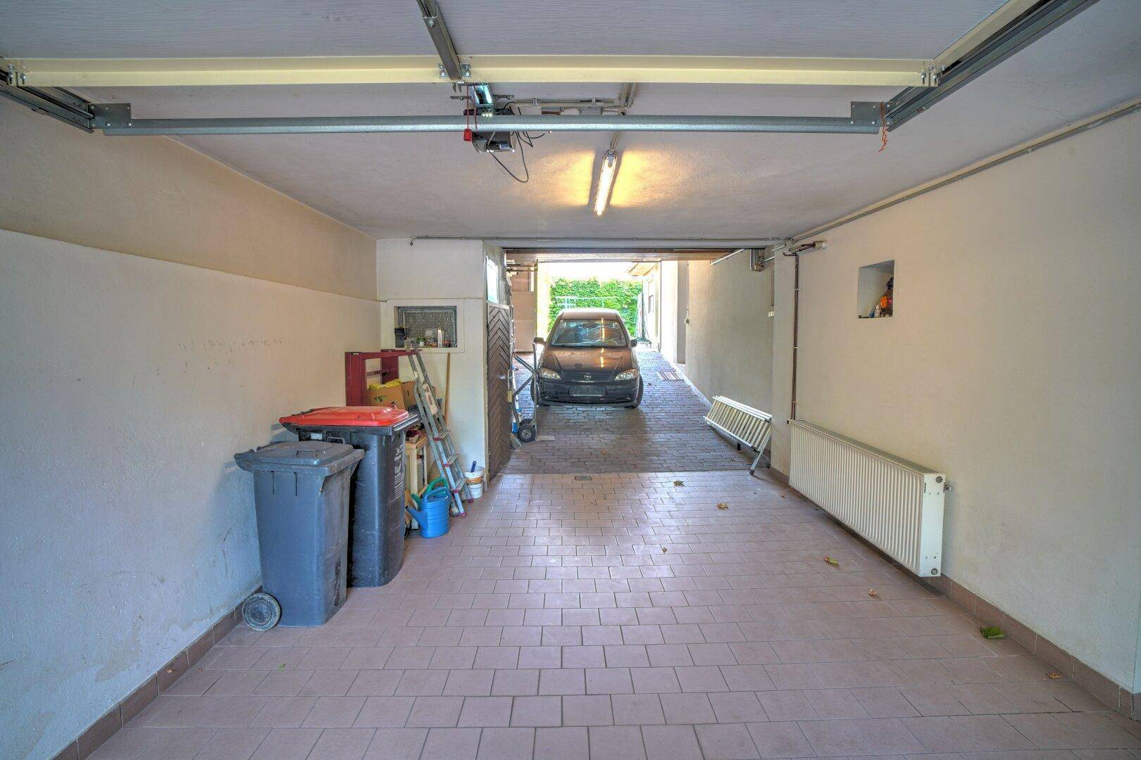 Geräumige Garage mit Fliesenboden und direktem Zugang zur Einfahrt.