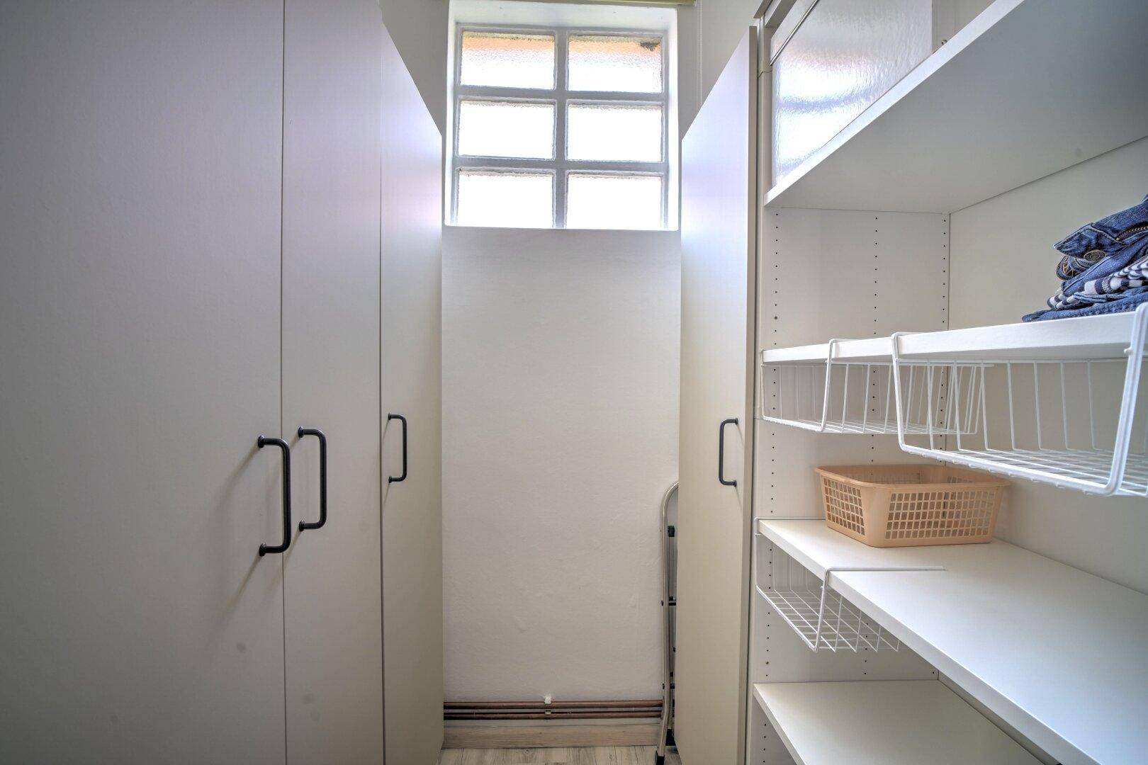 Praktischer begehbarer Kleiderschrank mit Regalen und Schränken, bietet viel Stauraum.