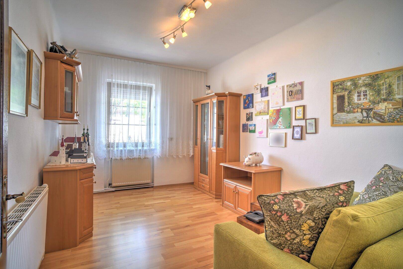 Helles Wohnzimmer mit Holzboden und moderner Dekoration, bietet einen gemütlichen Sitzbereich.