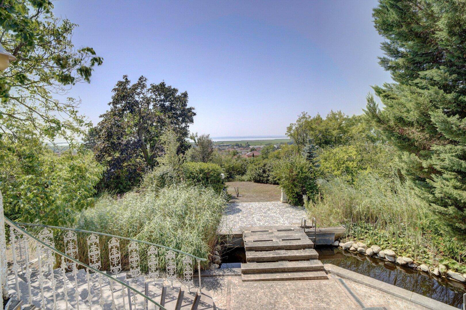 Terrasse mit weitem Blick über die grüne Landschaft und den Gartenteich.